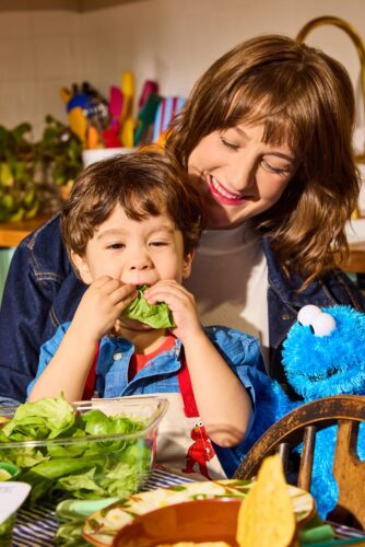 Gotham Greens + Sesame Street collaboration: a toddler eats a piece of lettuce